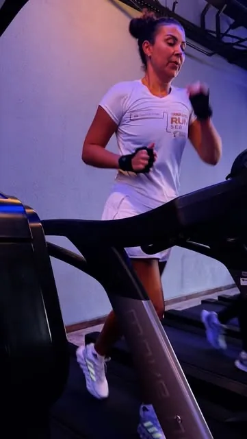 Aluna treinando na esteira com luvas