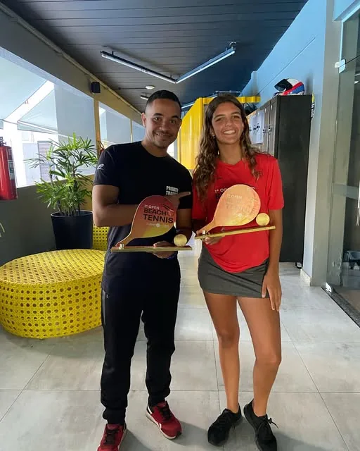 Jadson com uma aluna segurando troféus